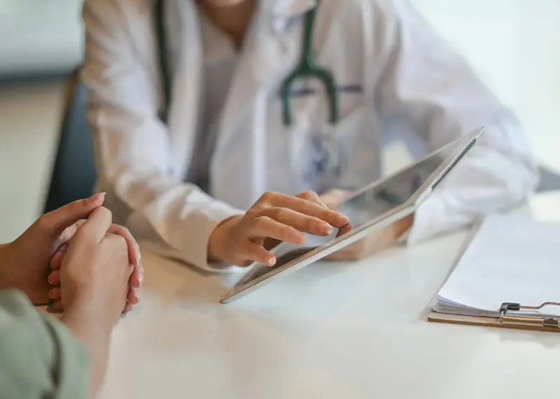 Blurred doctor pointing at tablet
