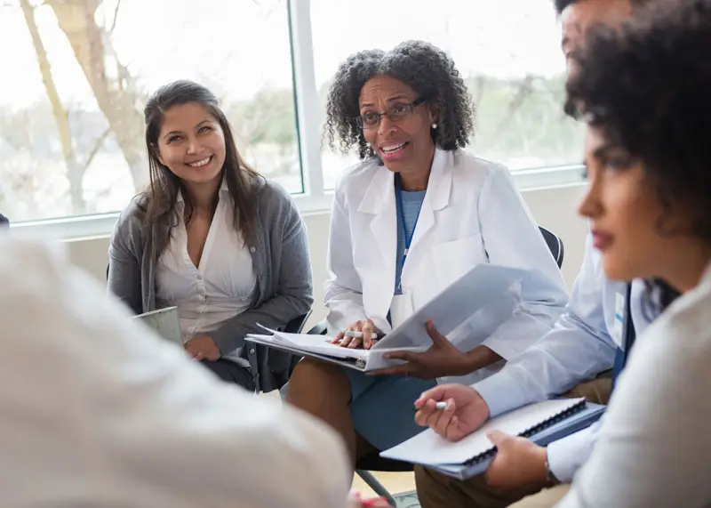 Clinicians sitting in a circle talking
