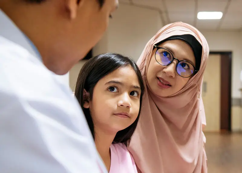 Mother and daughter looking at doctor